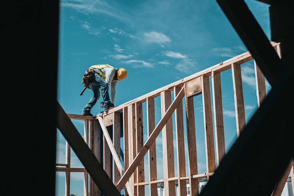Builder on the timber frame of a house under construction